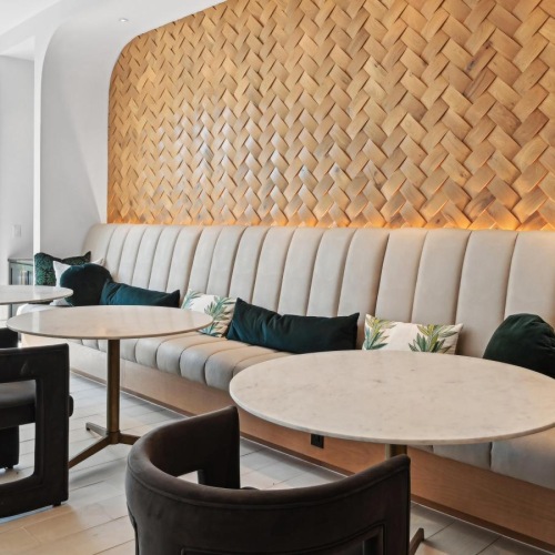 a seating area with small tables and a large window